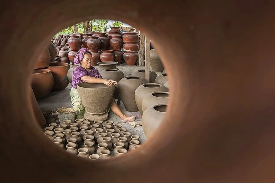 A potter shaping clay on a wheel